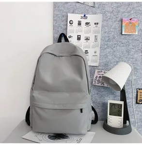 Detailed view of a grey minimalist backpack with a front zipper pocket and side pockets