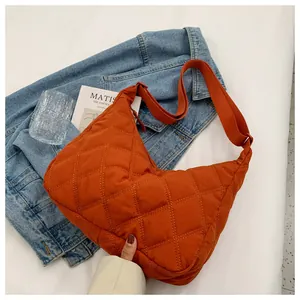 Detail der orangefarbenen gesteppten Halbmondtasche aus Nylon mit verstellbarem Schultergurt