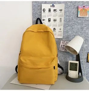 Detail view of the yellow canvas backpack with spacious front pocket and side compartments