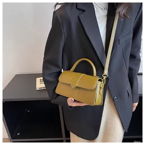 Detail of olive green structured handbag with gold hardware and removable shoulder strap