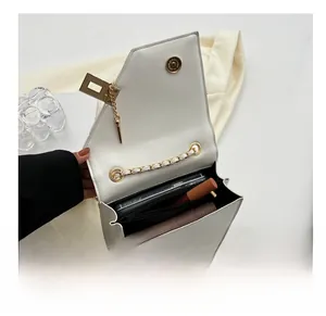 Interior view of white crossbody bag showing storage capacity for phone and lipstick