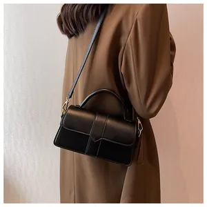 Chic black faux leather handbag with arrow stitching on a model for work style