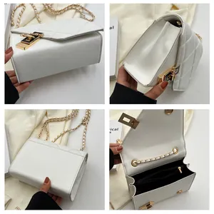 Detail view of white quilted crossbody bag showing chain strap and interior pocket