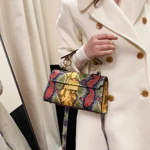 Colorful snakeskin pattern crossbody bag with gold lock shown on an elegant model