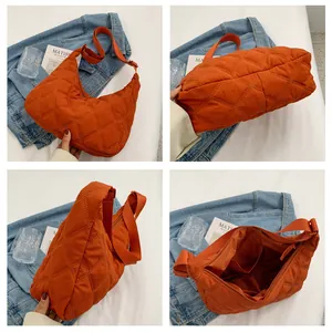 Detailaufnahmen der orangefarbenen Stepptasche zeigen Textur, Futter und Struktur