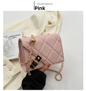 Detail of pink quilted square bag featuring a gold chain and adjustable metal ball buckle