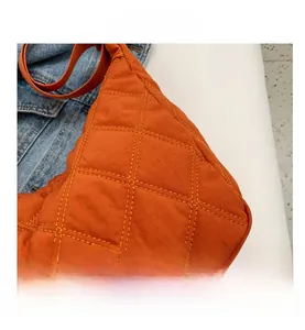 Detailansicht der orangefarbenen Stepptasche mit klassischem Rautenmuster Design