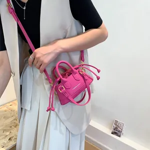 Mini hot pink shoulder bag with drawstring inner pouch and dual handles shown on model