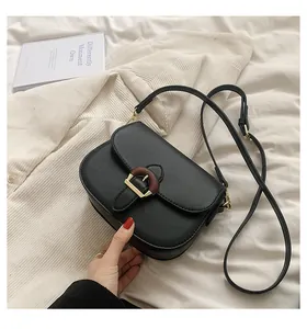 Close-up of black saddle bag with distinctive gold and wood texture buckle detail