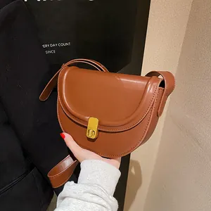 Classic caramel brown saddle bag with golden metal buckle and adjustable shoulder strap