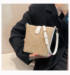 Detailed close-up of woven honeycomb straw texture and white leather strap on a bucket bag