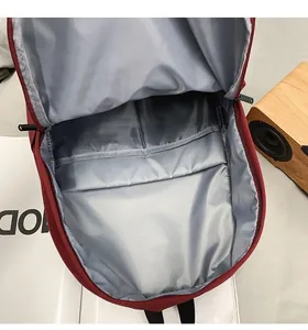 Internal detail of burgundy backpack showing spacious main compartment and two open pockets