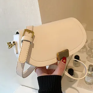 Fashionable cream white saddle crossbody bag with golden buckle and sleek leather texture