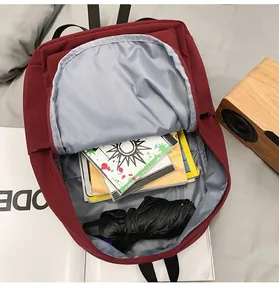 Detailed interior of a deep red backpack showing spacious storage for books and an umbrella