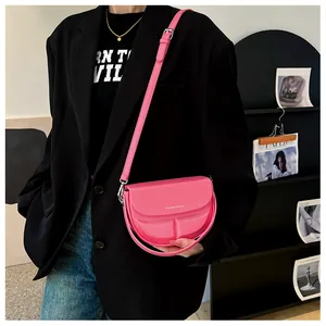 Rosafarbene Satteltasche als Umhängetasche mit verstellbarem Gurt am schwarzen Blazer