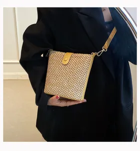 Straw shoulder bag detail showing woven texture with yellow leather flap and adjustable strap