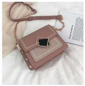 Détail du sac bandoulière rose avec broderie d'épi et fermoir géométrique doré