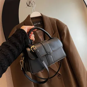 Elegant black leather handbag with crossbody strap and gold buckle for women