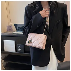 Detail of pink quilted chain bag with gold metal turn-lock closure on model