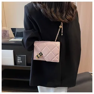 Detail of pink quilted shoulder bag with gold chain strap and black metal square clasp