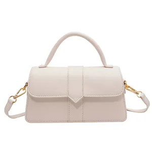 Chic cream-colored PU leather handbag with V-shaped buckle and gold hardware on white background