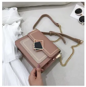Détail d'un sac bandoulière en cuir rose avec boucle métallique et chaîne dorée