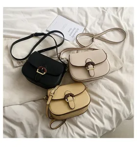 Detailed view of three vintage saddle bags in black, beige, and yellow on a soft fabric