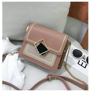 Détail du sac bandoulière rose et beige avec broderie de feuilles et ferrures dorées