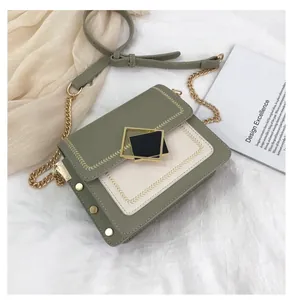 Détail du sac à main bicolore vert et beige avec fermoir doré et coutures décoratives