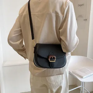 Elegant black saddle crossbody bag for women with a unique wood grain metal buckle
