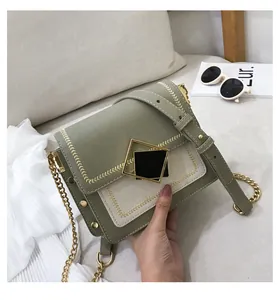 Détail du sac bandoulière vert tendance avec fermoir doré et bandoulière chaîne