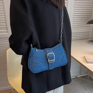 Borsa baguette in denim blu con fibbia argento e catena su blazer nero