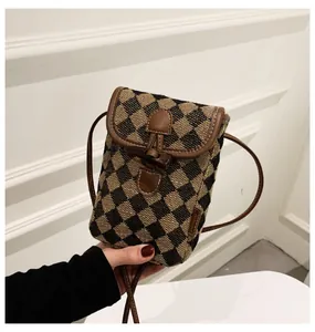 Brown and black checkered crossbody phone bag with toggle closure and leather trim