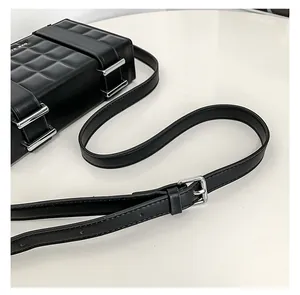 Detailed close-up of 3D checkered texture and white ITE BAG logo on a black crossbody bag