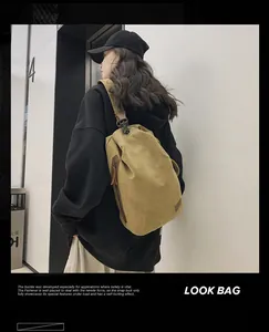 Borsa a tracolla in tela kaki con cerniere in metallo e finiture in pelle sul modello