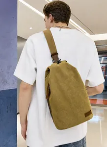 Vue détaillée du sac bandoulière vintage en toile sur modèle montrant taille et texture