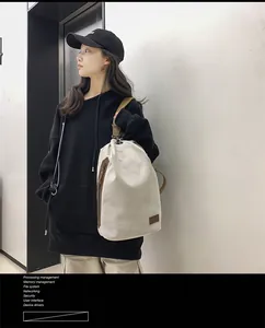Dettaglio della borsa a tracolla in tela con finiture in pelle e tasca laterale con zip