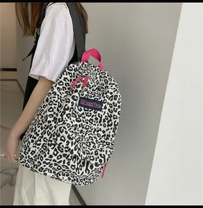 Détail du sac à dos en toile imprimé léopard avec poignée rose et logo de la marque MRMIBAG