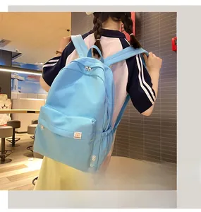 Close-up of a light blue student backpack showing the bear label and durable fabric texture