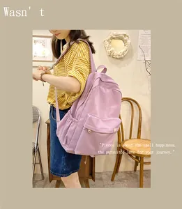 Side view of a student carrying a solid light purple canvas backpack in a warm room
