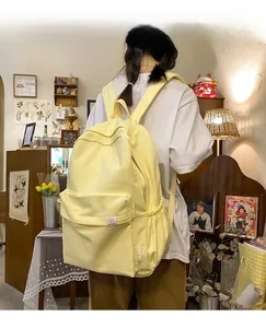 Detail of light yellow canvas backpack featuring bear patch and adjustable side pocket