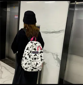 Détail du sac à dos Harajuku en toile à motif vache avec poignée rose et logo MRMI