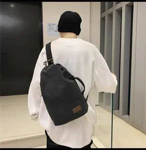 Dettaglio borsa a cilindro in tela nera con patch in pelle e fibbia metallica vintage
