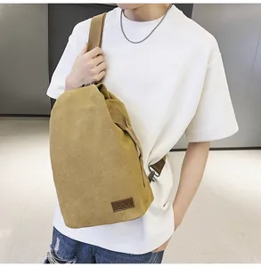 Gros plan du sac bandoulière en toile gingembre avec sangle réglable et écusson en cuir