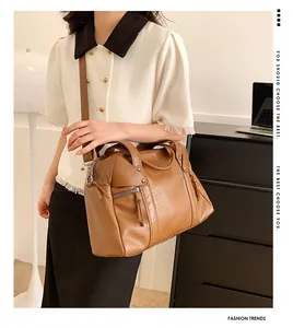 Close-up of brown Boston bag with tassel zipper and detachable shoulder strap