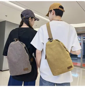 Détail de sacs bandoulière en toile lavée avec patch logo en cuir et boucles métal