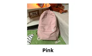 Detailed close-up of a pink canvas backpack with cute cartoon tags and large front pocket
