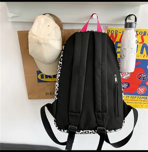 Détail du sac à dos léopard avec bretelles réglables et poignée rose contrastée