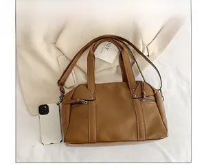 Detailed size comparison of the vintage brown Boston bag next to a smartphone