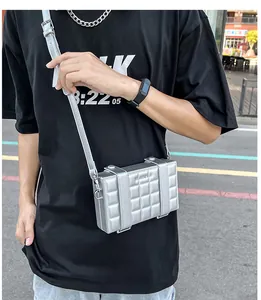 Silver quilted box crossbody bag with metallic finish shown on a model in urban setting